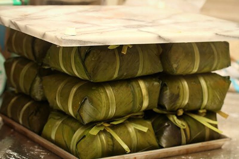 Đè vật nặng lên bánh chưng khi vừa nấu xong cũng giúp bánh chắc chắn hơn